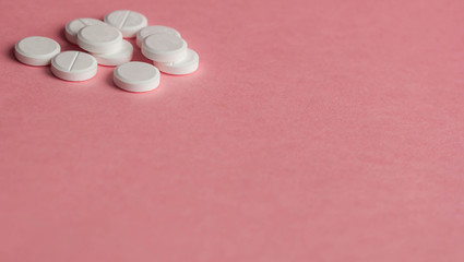 White pills on a pink background. Place for text on the left.