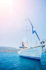 Boy jump in sea of sailing yacht on summer cruise. Travel adventure, yachting with child on vacation.
