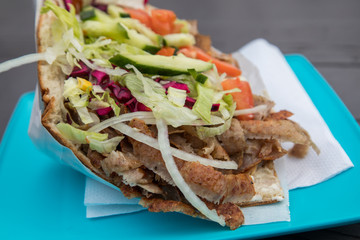 Döner im Fladenbrot mit Salat und Kalb Fleisch draußen an Imbiss Bude