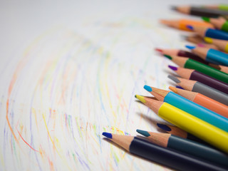 assortment of colored pencils on a white background, with colored lines