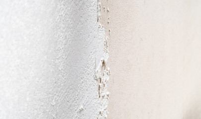 Construction worker plastering and smoothing concrete wall with cement