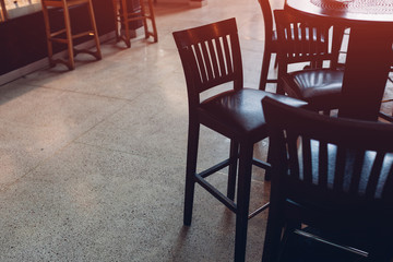 Empty cafe. Wooden chairs beside bar counter.