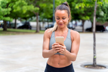 An athletic woman using her smartphone in the park