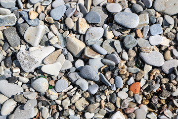 Different pebbles on the beach background