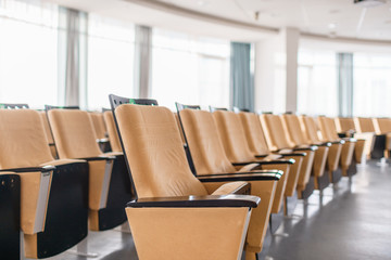 Fototapeta premium Folding chairs close-up. Big empty modern conference hall in luxury hotel. Audience for Speakers at Business convention and Presentation. Photo for illustration meeting, seminar, conference