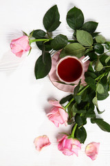 Pink porcelain cup of tea with a saucer on a white background, with pink roses. Holiday concept. Concept greeting card. There is free space for the inscription.