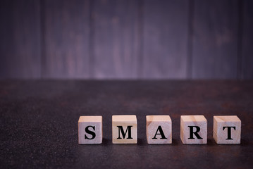 The word smart on wooden cubes, on a dark background, symbols signs