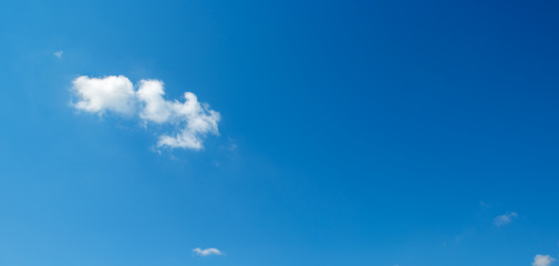 Fototapeta na wymiar Small white clouds against blue sky.