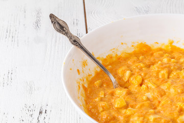 Process of preparation of cupcakes. Adding pumpkin to the dough