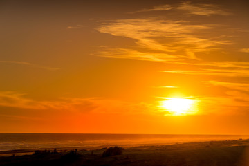 Obraz na płótnie Canvas Golden sunset on the beach with the sun over the beach