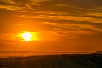 Fototapeta na wymiar Golden sunset on the beach with the sun over the beach