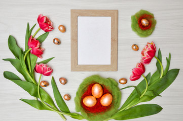 Easter rustic greeting card template. Arrangement of flowers of tulips and Easter eggs in the nest. Top view, flat. Decorative floral element. Holiday card. Easter holiday concept. Festive background.
