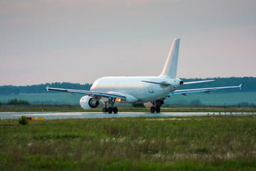 Obraz premium White passenger airplane taxiing to the runway