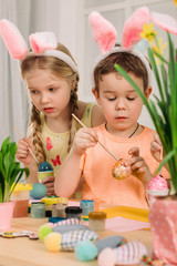 cute kids painting Easter eggs at home. adorable children prepare for easter