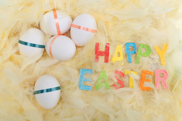 Easter background with Easter eggs and feather nest. Top view with copy space.