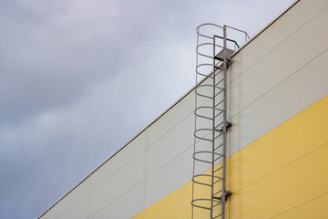 Ladder to the roof of a tall building on a dark sky background