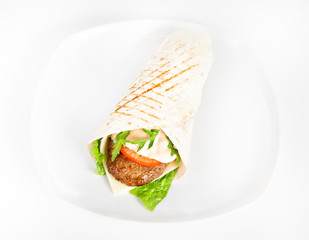 Wrap sandwich with meat steak, cheese, tomato and greenery on white