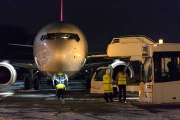 Fototapeta premium Passenger aircraft at night at airport. Airplane in winter at night at airport.