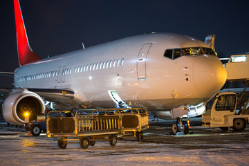 Fototapeta na wymiar Passenger aircraft at night at airport. Airplane in winter at night at airport.