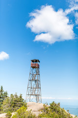 an old fire tower with a woman perched on top