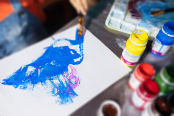 Art palette with paint and brushes, close up, top view