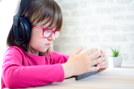 People, children and technology concept - girl with headphones listening to music. Horizontal.