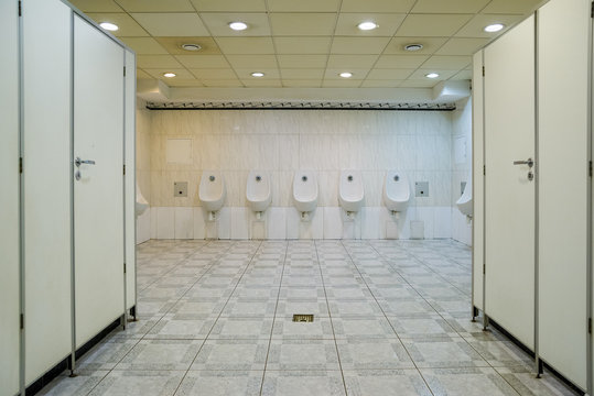men's wall urinals in the toilet with cabins