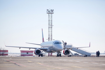 Passenger plane at airport in winter afternoon. plane on airport platform in  winter. Airplane on summer strip in winter