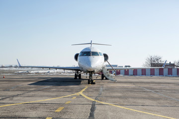 Fototapeta na wymiar Passenger plane at airport in winter afternoon. plane on airport platform in winter. Airplane on summer strip in winter