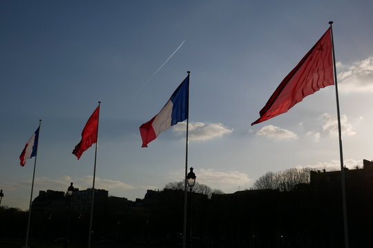 French and Chinese flags on background of blue sky, Paris