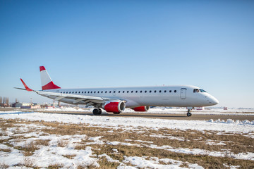 Passenger plane at airport in winter afternoon. plane on airport platform in  winter. Airplane on summer strip in winter