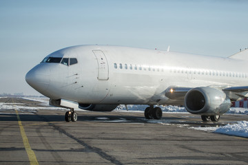 Passenger plane at airport in winter afternoon. plane on airport platform in  winter. Airplane on summer strip in winter