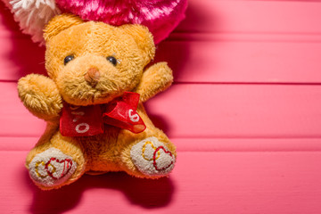 teddy bear holding pink heart with the word love