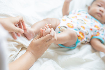 Obraz na płótnie Canvas Mother making infant baby boy foot massage