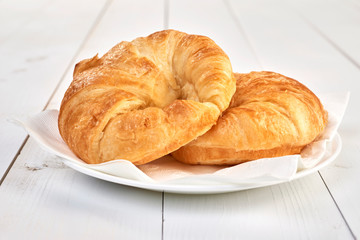 fresh baked croissants on wooden table
