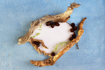 original frame in the form of a heart made of paper, small wooden blocks and cones on a blue terry...