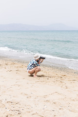 woman tourist photographer taking photo with digital camera on sea shore Rethymno Crete