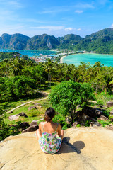 Fototapeta na wymiar Koh Phi Phi Don, Viewpoint - Girl enjoying beautiful view of paradise bay from the top of the tropical island. View from the back. Thailand.