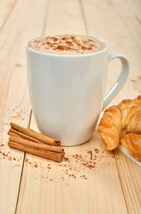 Coffee and croissants on wooden table