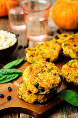 black bean millet pumpkin burgers with spinach leaves on a wood background