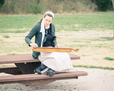 Girl Playing Mountain Dulcimer In Park