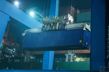 operation of container terminal at night. Unloading container ship at night. Mooring cranes unload...