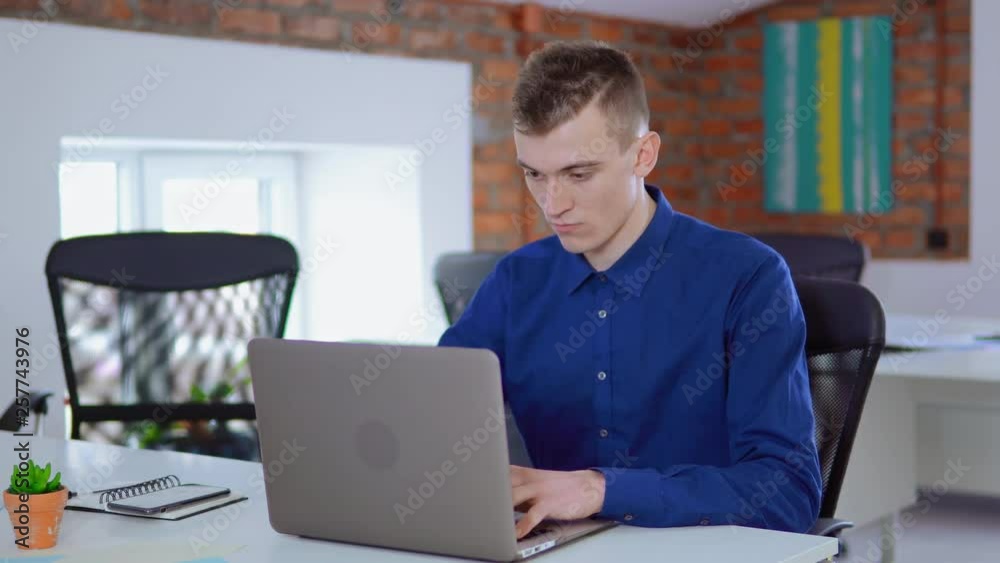 Poster businessman focused looking on display computer entering data on pc at work daytime young worker loo