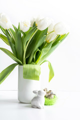 Easter. White tulips in vase, bunny and eggs on white.