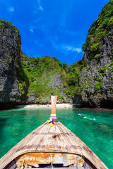 Wang Long Bay with crystal turquoise water, Tropical island Koh Phi Phi Don, Krabi Province, Thailand - Long boat in beautiful lagoon with rocks covered with a plants