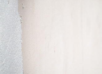 Construction worker plastering and smoothing concrete wall with cement