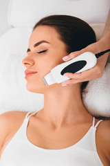 Beautiful woman receiving ultrasonic facial exfoliation at spa. Procedure clearing clogged pores, ultrasonic treatment for skin rejuvenation