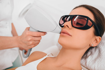Woman getting laser hair removal on her face , hair removal on lip area