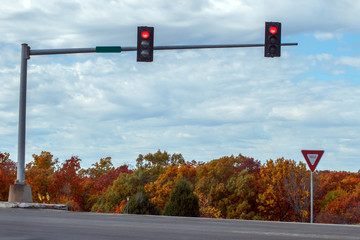 Red traffic lights against a blue sky on a fall day in Missouri makes a colorful road trip scene.