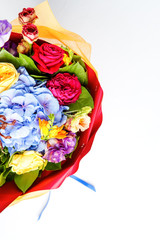 Photo from above of bouquet of multi-colored roses on empty white background.